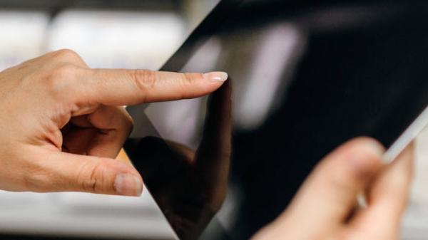 Image of female using tablet and pointing at screen